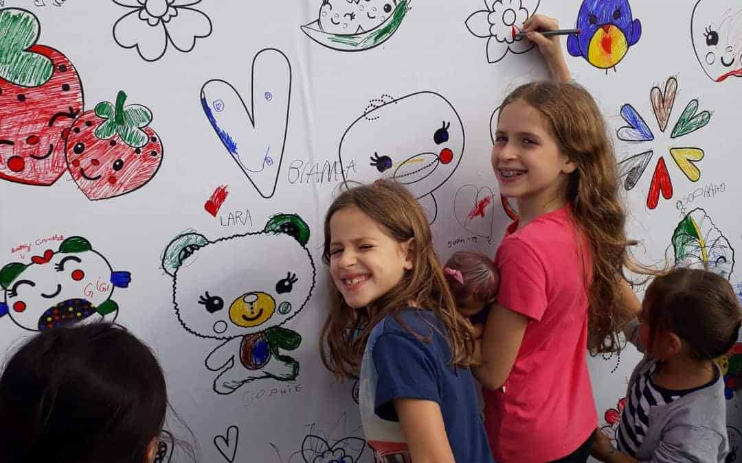 Crianças pintando em um painel, no Piquenique