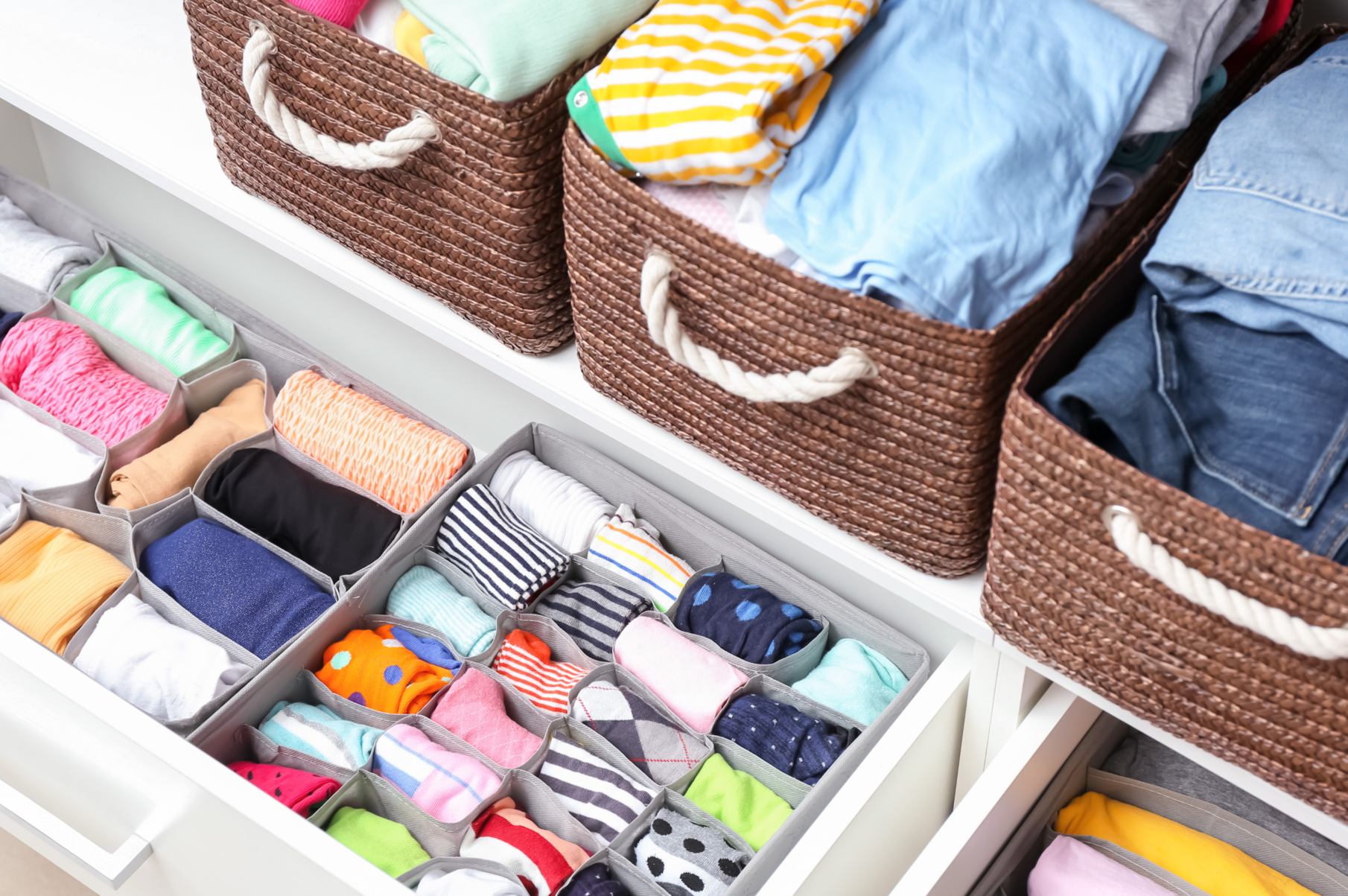 Closet organizado por Elaine Gouvea com roupas separadas por categorias e disposição funcional.